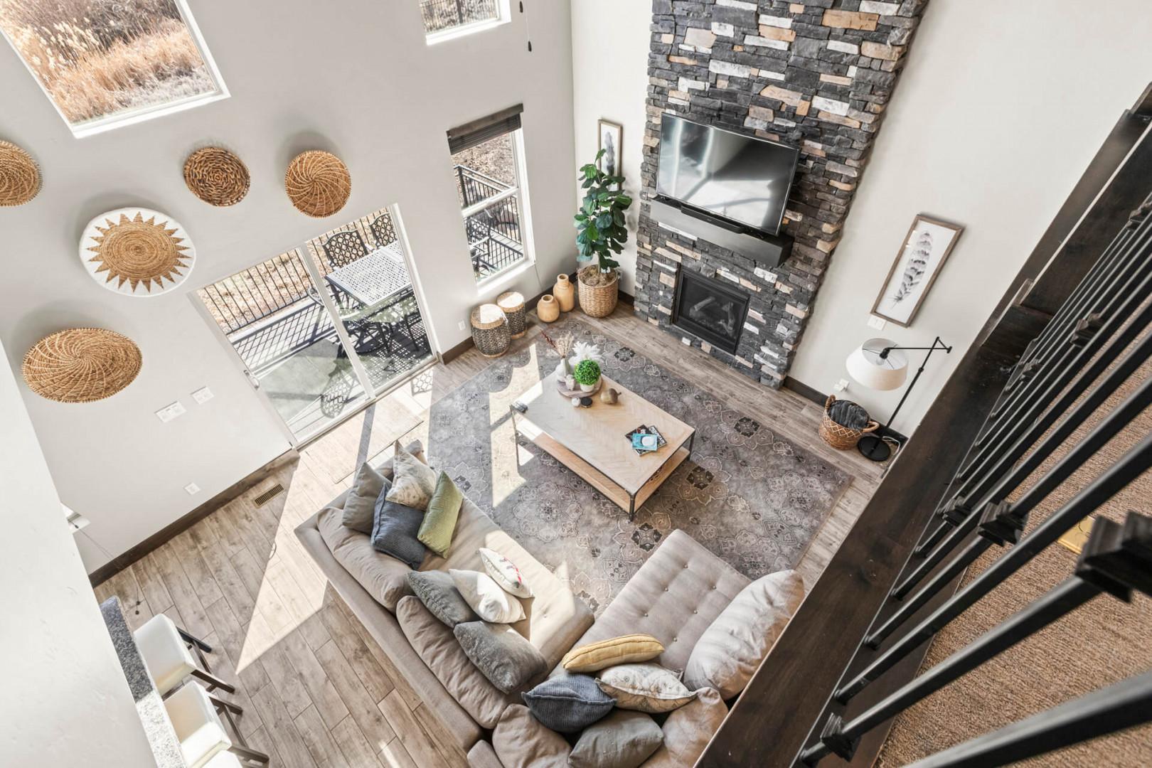Relax in your spacious living room with cozy sectional seating, stone fireplace, and stylish decor that creates the perfect atmosphere for unwinding.