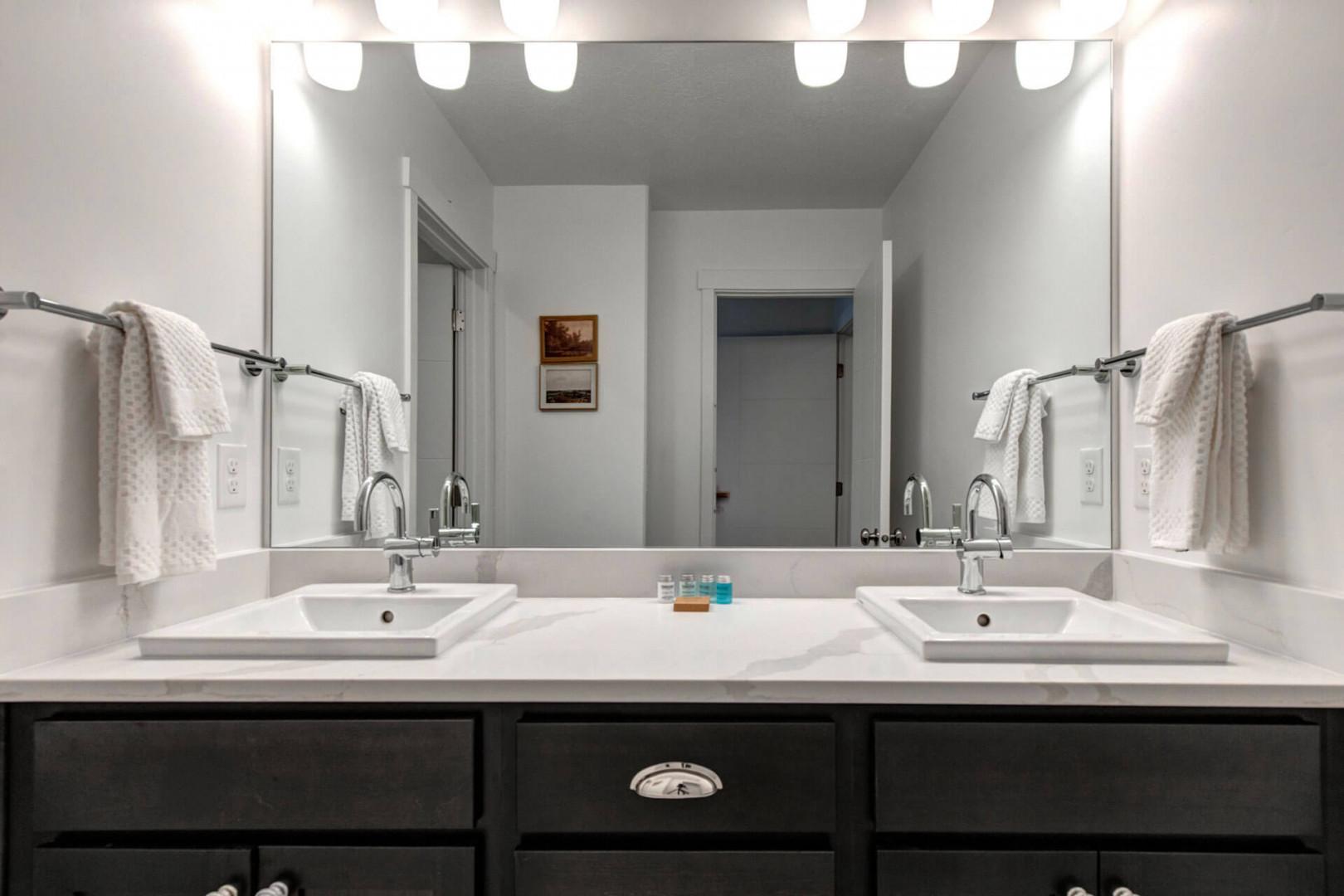 Freshen up in your spacious dual-sink bathroom with Hollywood-style lighting and plush towels awaiting your arrival.