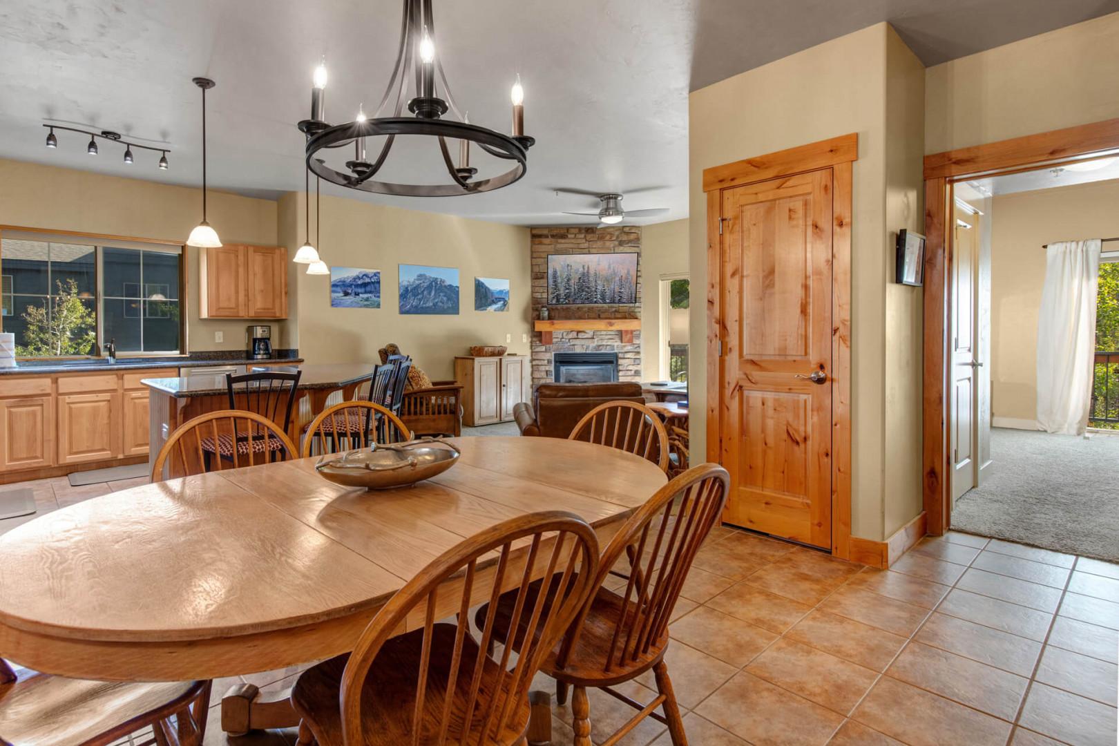 Gather around this inviting dining table where your group can share meals and make memories together. The open layout flows seamlessly into the cozy living area with a stone fireplace, creating the perfect space for your mountain retreat.
