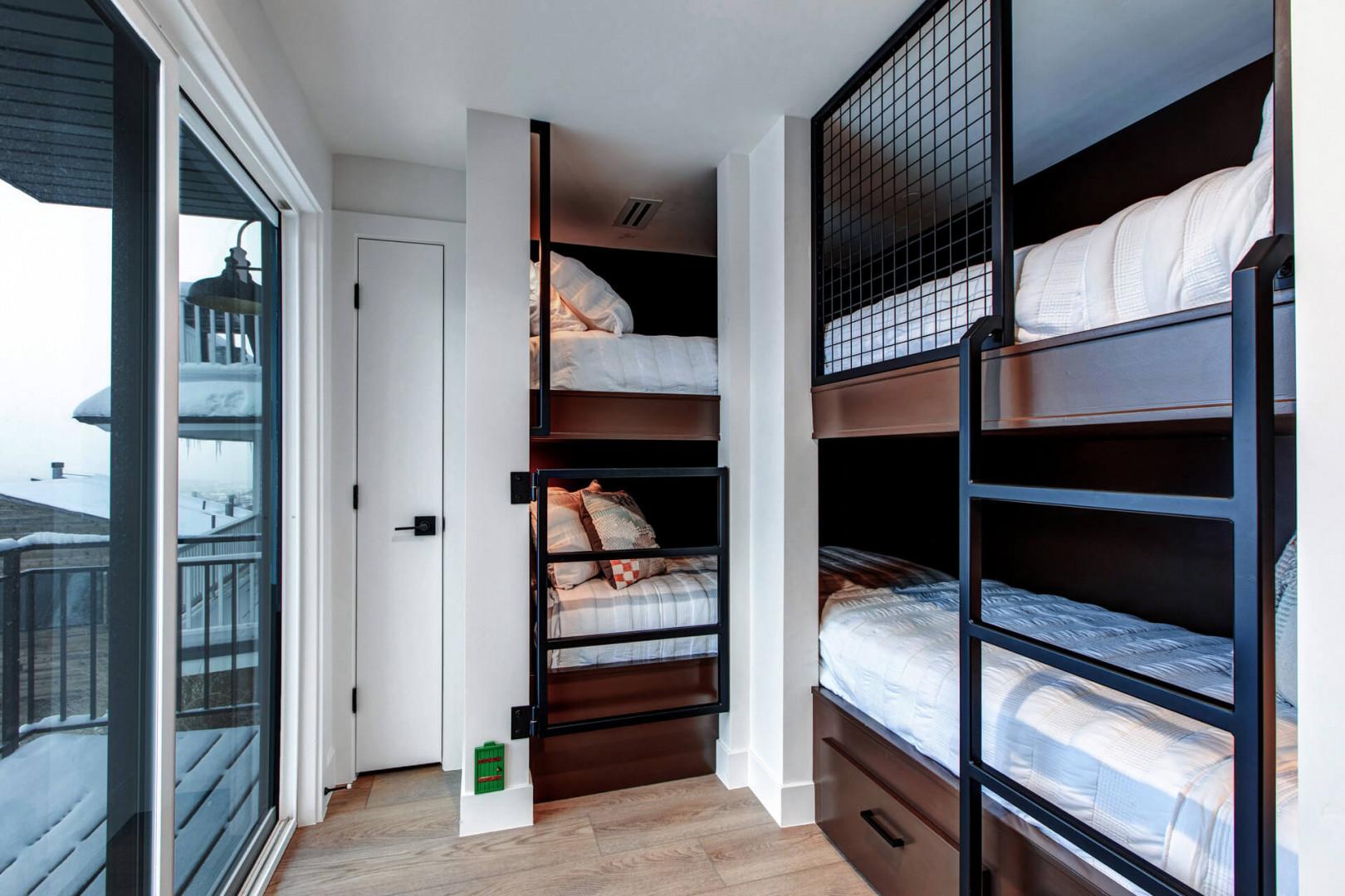 Your cozy bunk room features modern built-in beds with privacy screens, perfect for groups or families seeking comfort and style.