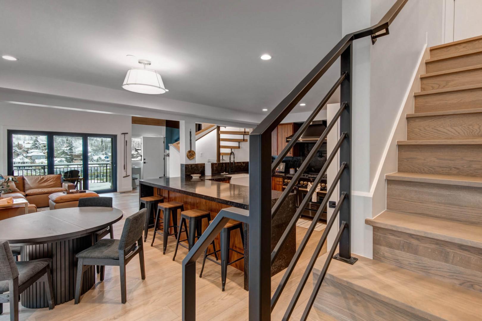 Upper Main 301: Step into your modern mountain retreat where sleek kitchen island meets warm wood stairs, perfect for gathering after adventures.