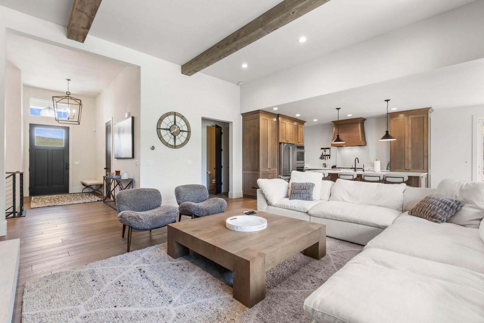 Picture yourself unwinding on the plush sectional, where exposed beams add rustic charm to this light-filled, open-concept living space that flows seamlessly into the gourmet kitchen.