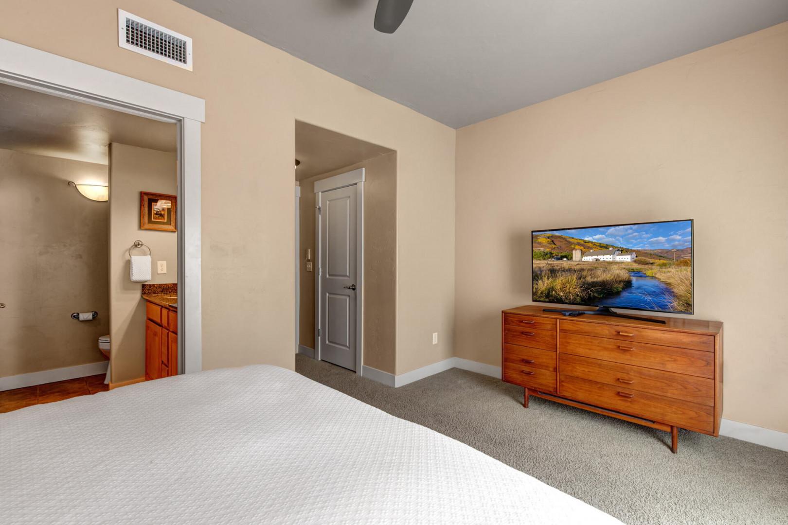 Unwind in your peaceful bedroom with modern comforts, including a flat-screen TV and ensuite bathroom, all set in a spacious, serene setting.