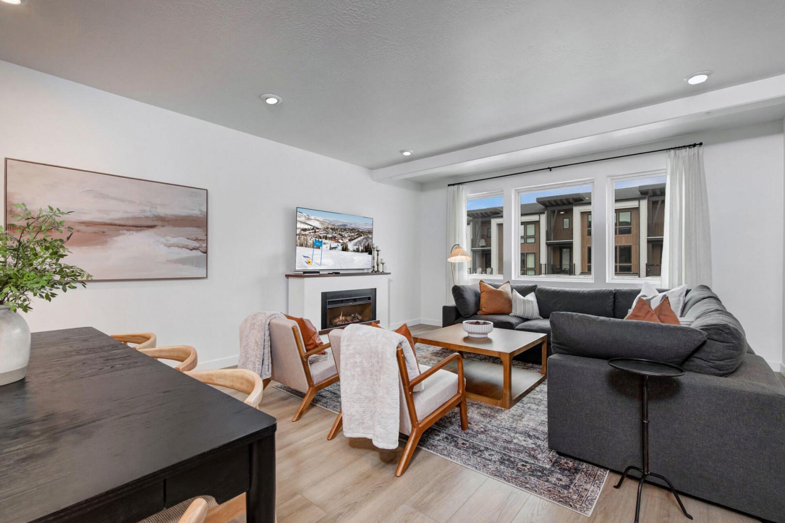 Unwind in your stylish living room with a cozy fireplace, plush sectional, and warm natural light streaming through oversized windows.