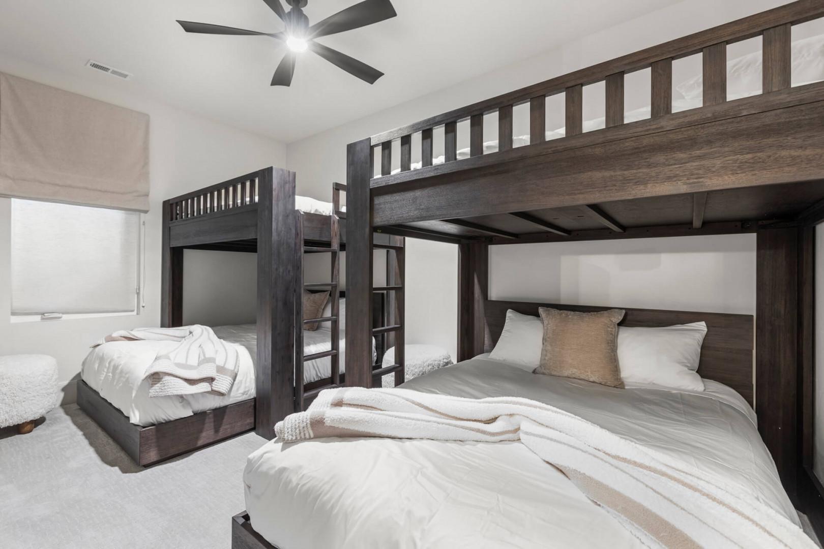 Sink into plush bedding in this spacious bunk room, where everyone can rest comfortably after a day of adventure. The modern dark wood frames and crisp white linens create a soothing retreat for your group.