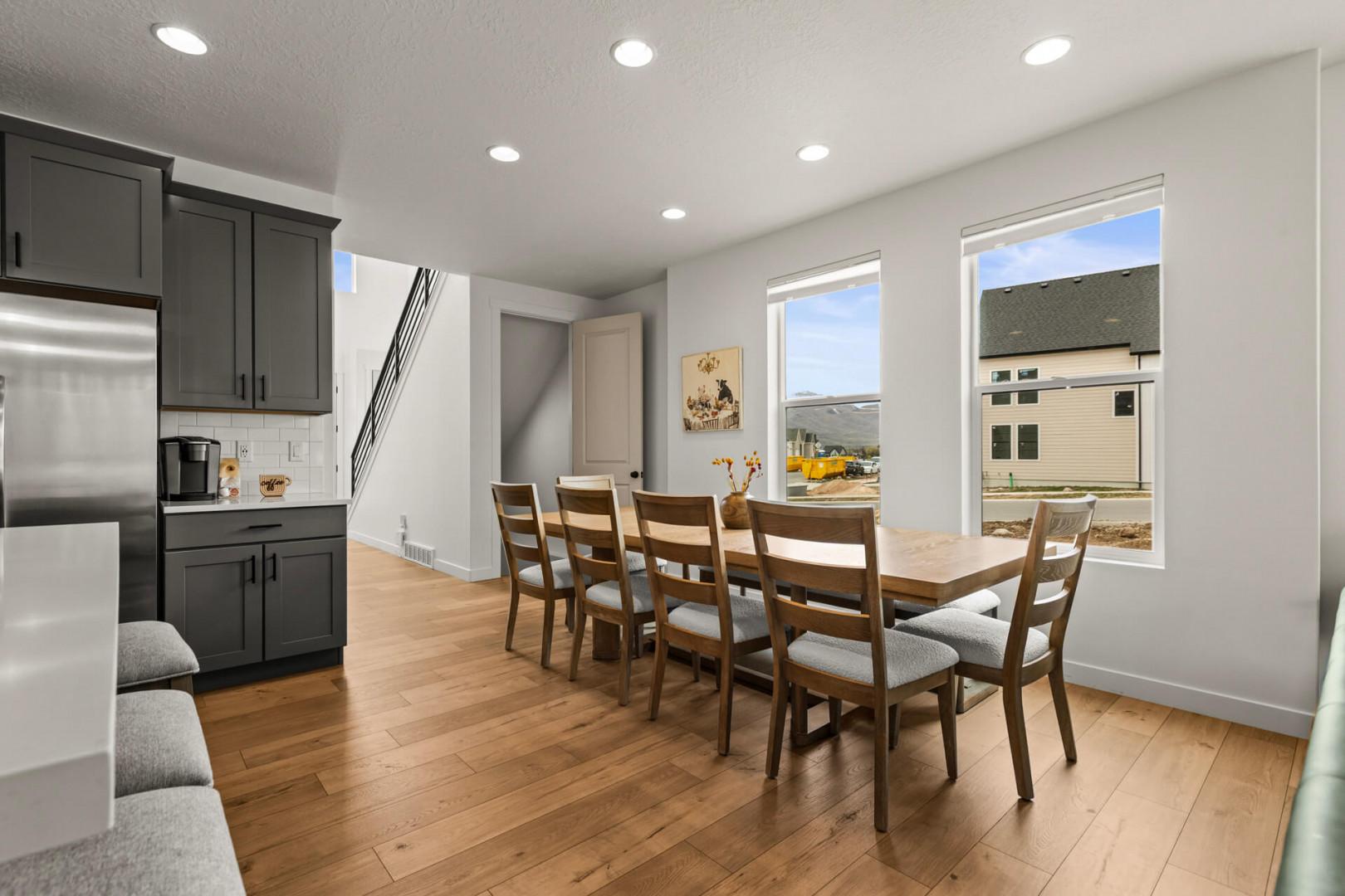 Gather around your spacious dining table for memorable meals, with natural light streaming through large windows and modern kitchen close by.