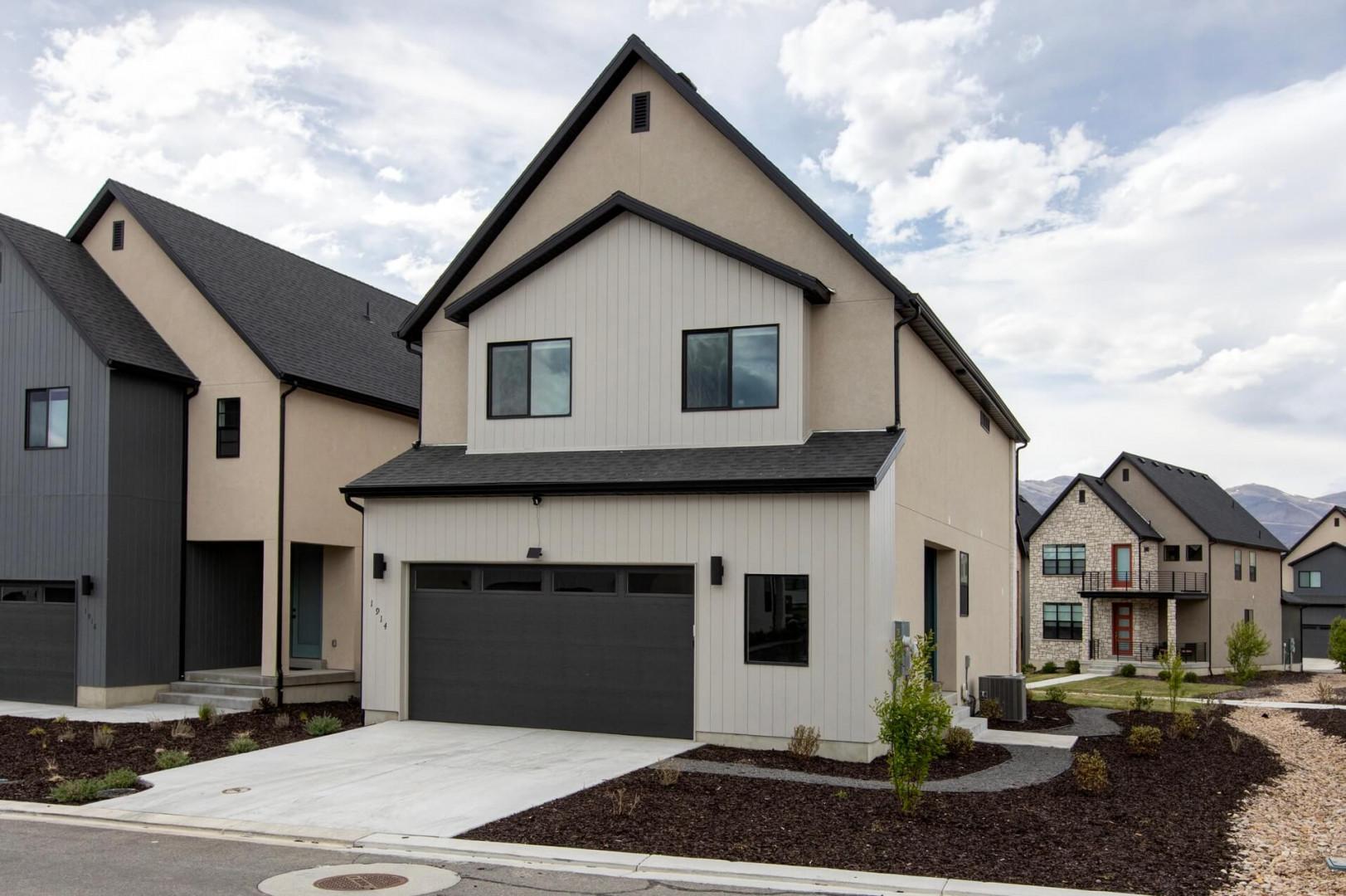 Modern property building featuring contemporary architecture in a well-developed residential neighborhood with mountain backdrop and manicured landscaping.