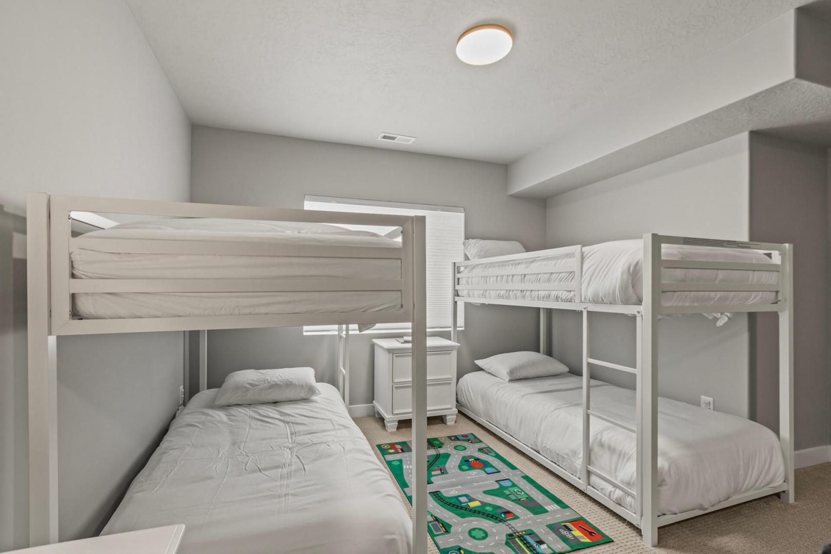 Your kids will love this cozy bunk room with four comfortable beds and a fun playmat for games and quiet time.