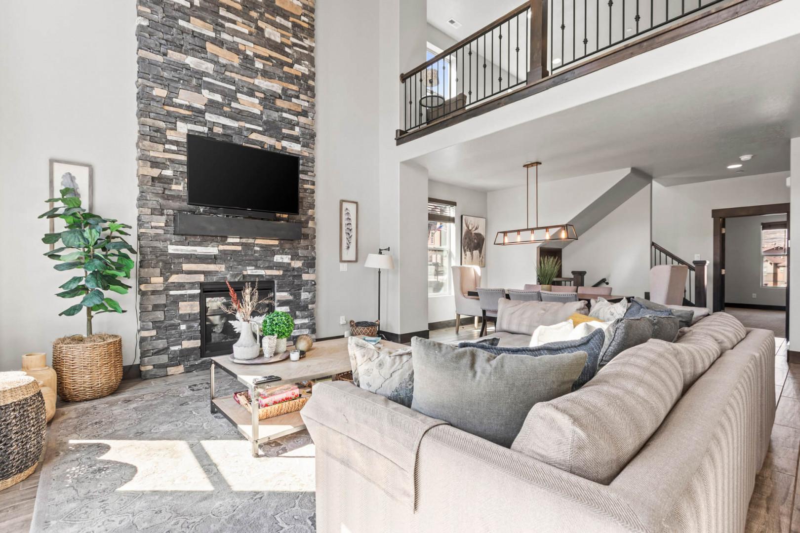 Sink into plush sofas by your stunning stone fireplace, where soaring ceilings and warm lighting create the perfect retreat.