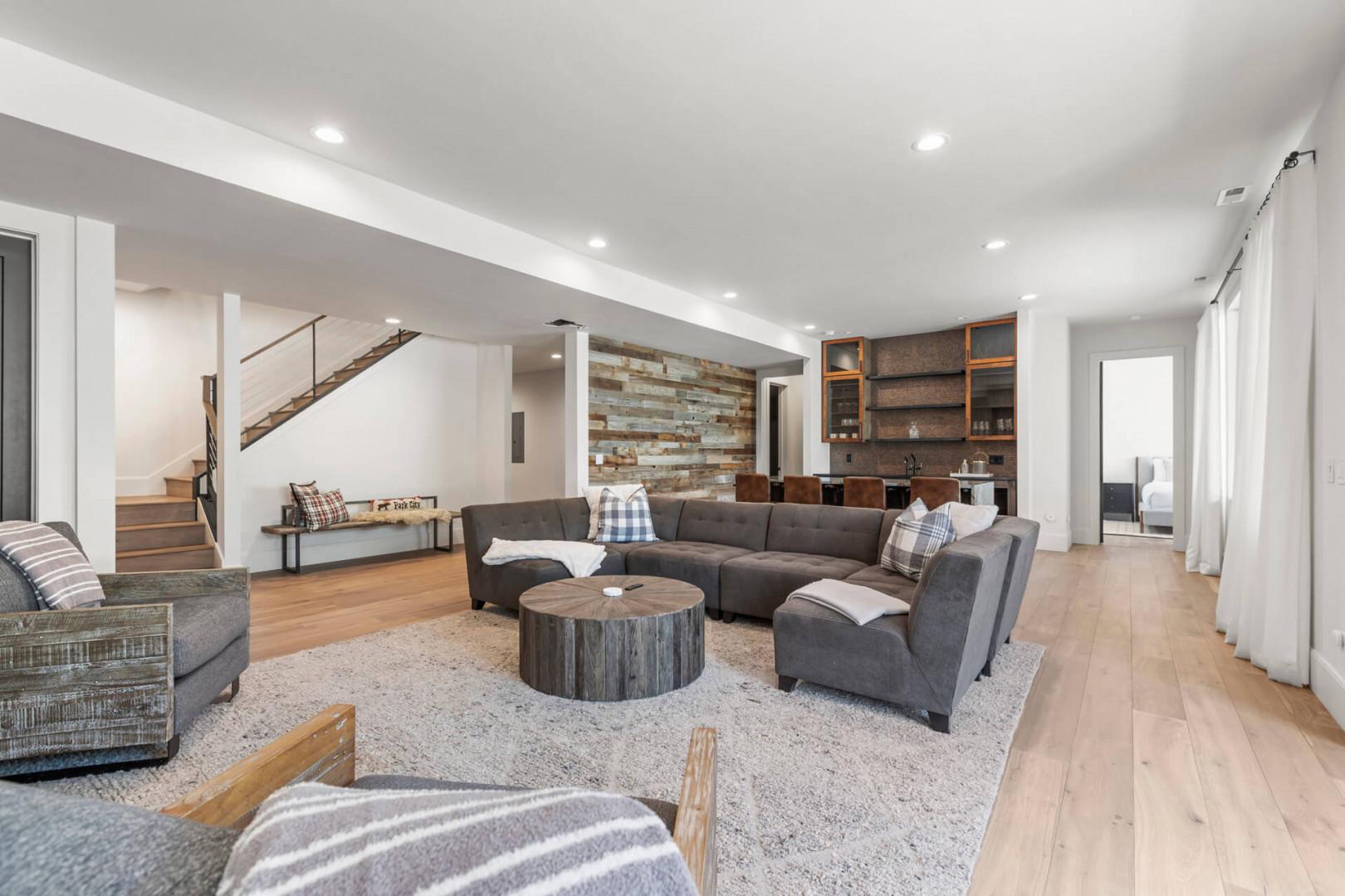 Sink into plush seating in this open-concept living space, featuring rustic wood accents, a cozy sectional, and a stylish bar area perfect for unwinding after a day of adventure.
