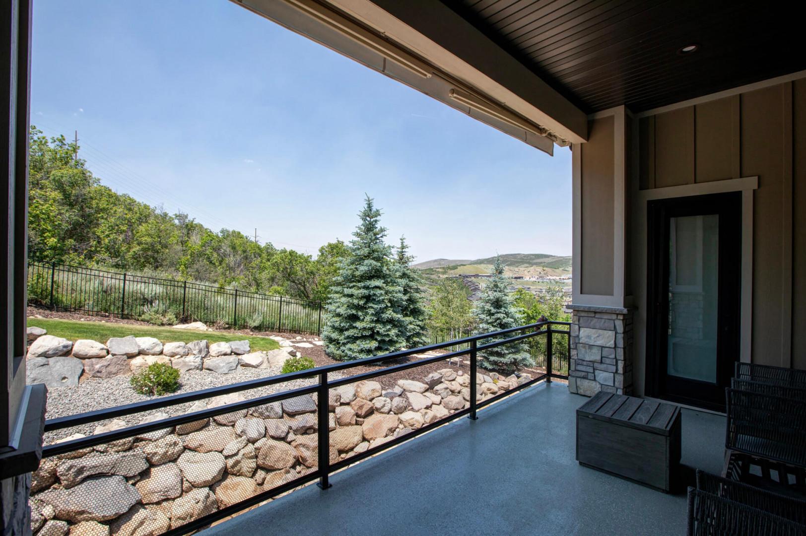 Step outside to your private covered terrace, where sweeping views of evergreens, rolling hills, and serene natural landscape surround you—a peaceful retreat awaits.