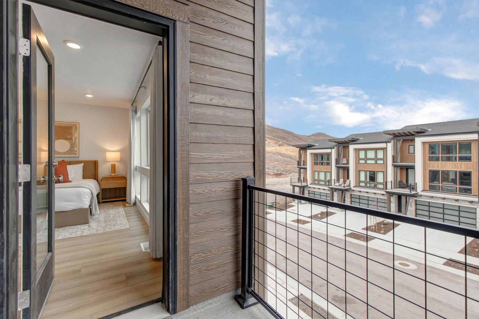 Step onto your private balcony and soak in sweeping mountain views, then retreat to your cozy bedroom sanctuary with warm wood accents.