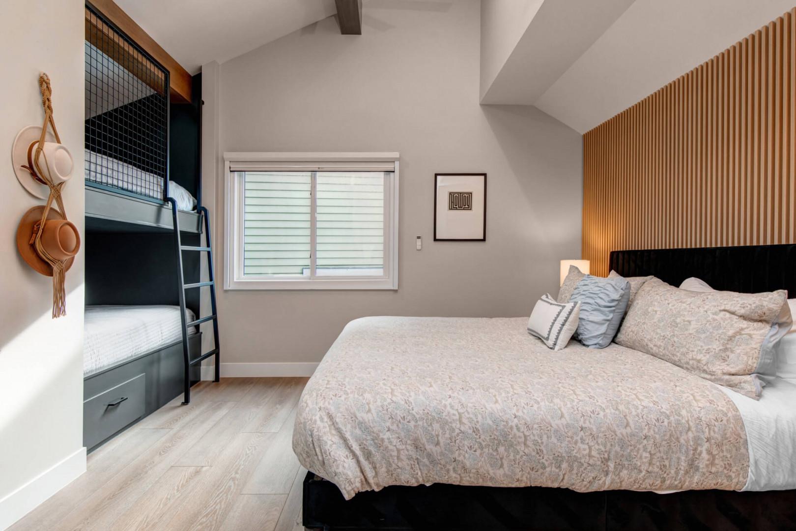 Upper Main 301: Drift off peacefully in your stylish bedroom featuring a cozy queen bed and fun bunk beds, perfect for families or groups.