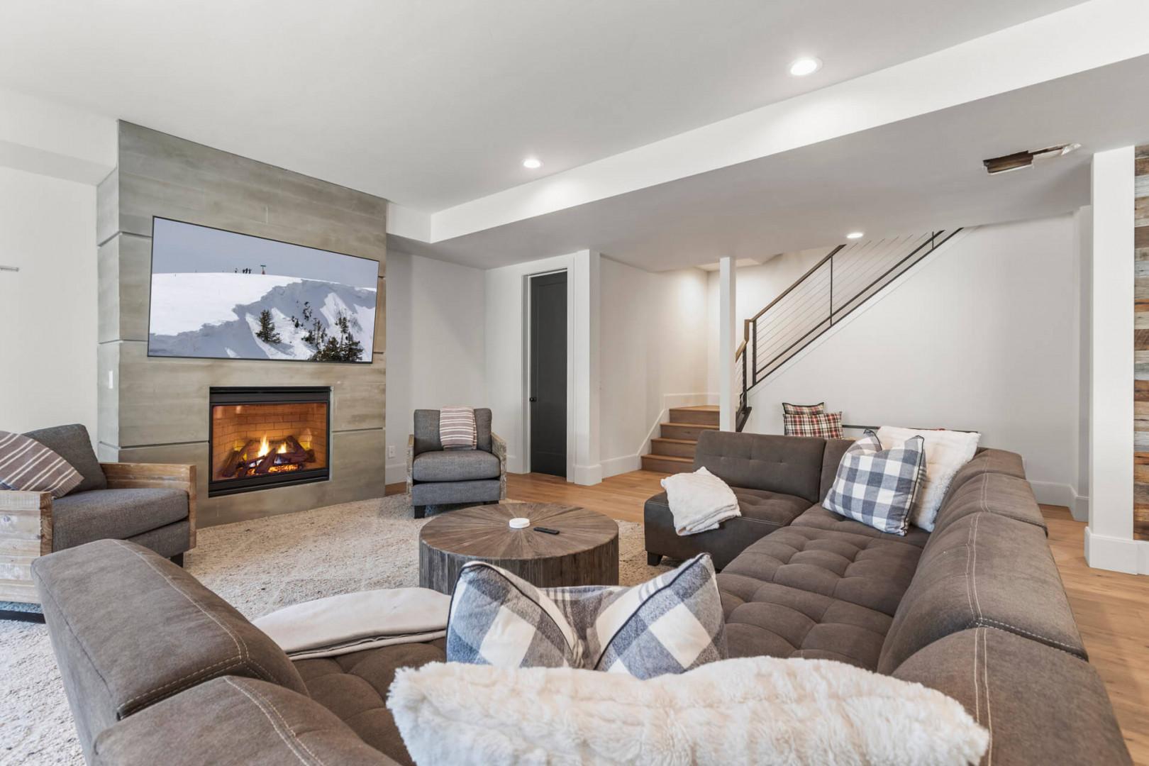 Sink into plush seating by the glowing fireplace, perfect for cozy evenings. The space feels modern yet inviting, with plenty of room to unwind after your adventures.