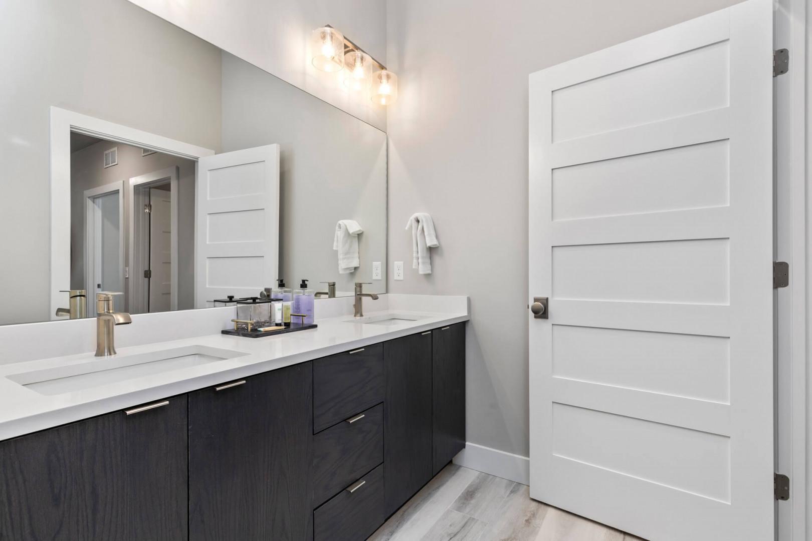 Mayflower Lakeside 301-45: Reflective sink area with a sleek mirror, perfect for morning routines.