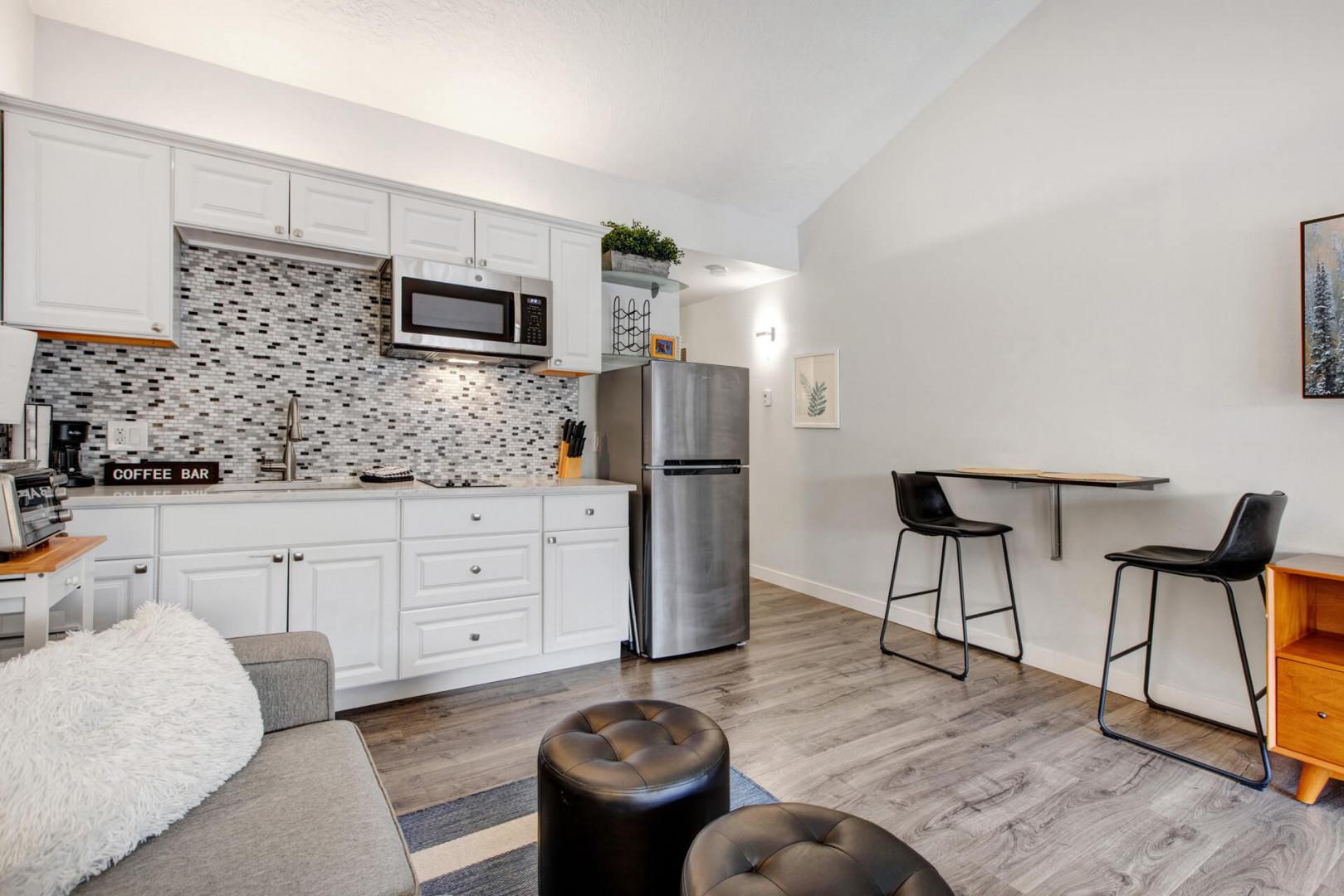 You'll love this modern open-plan space with its fully equipped kitchen, cozy seating area, and stylish breakfast bar perfect for morning coffee.