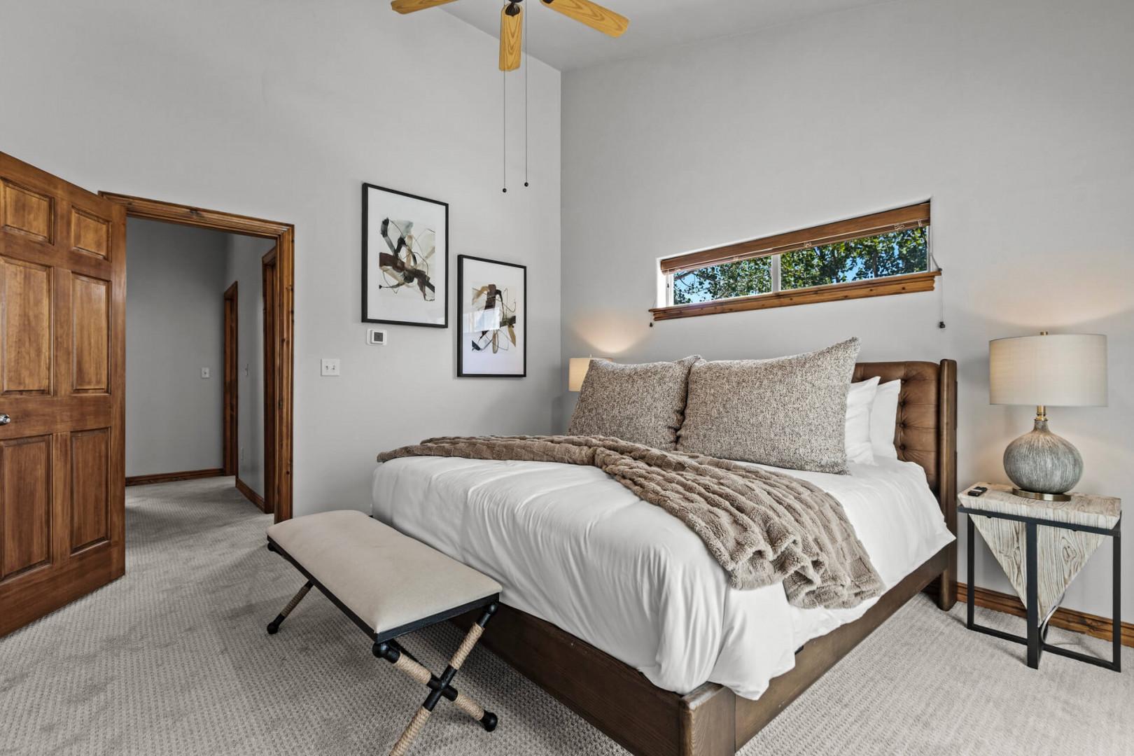 Your serene bedroom retreat features warm wood accents, plush linens, and a cozy throw blanket that invites you to unwind after a day of mountain adventures.