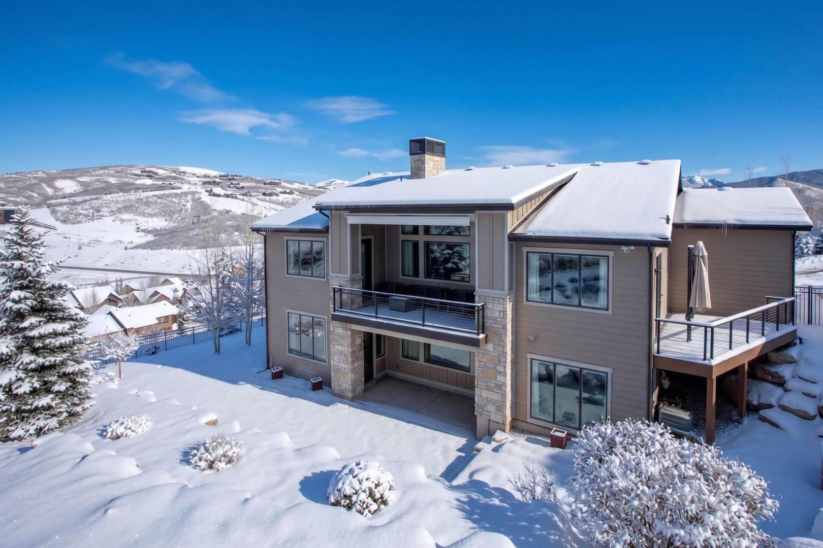 Modern mountain retreat set against pristine snow-covered slopes, offering expansive views of the surrounding winter landscape and nearby resort village.