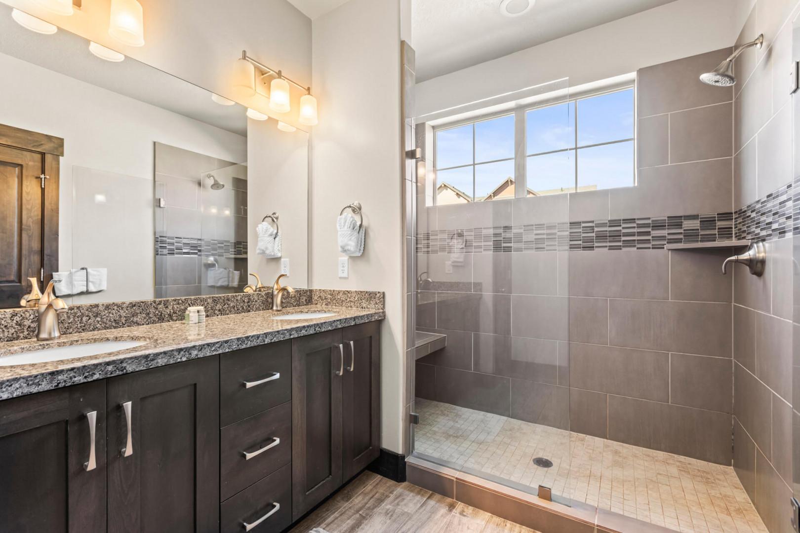 Step into your spa-like sanctuary with granite counters, walk-in shower, and natural light streaming through the window.