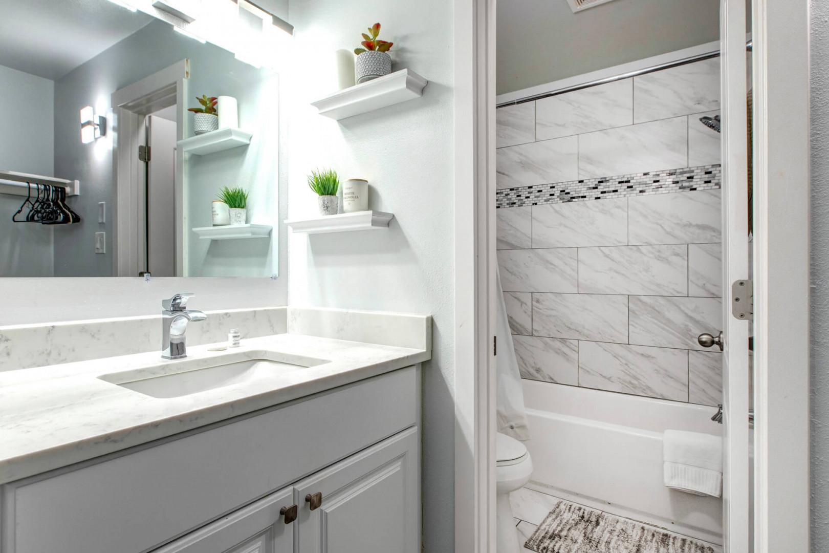 Refresh in this beautifully designed bathroom with marble tile shower, vanity storage, and thoughtful touches that make you feel right at home.