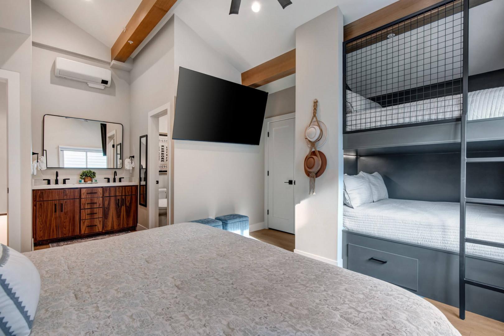 Upper Main 301: Your stylish bedroom combines comfort with modern amenities - plush bedding, built-in bunks, entertainment center, and sleek bathroom vanity for ultimate relaxation.