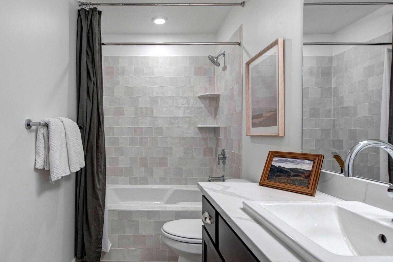 Your private bathroom features a soothing tiled tub-shower combo with fluffy towels and thoughtful touches for your comfort.