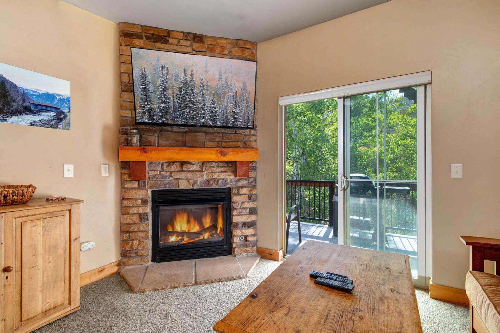 Cozy up by the glowing fireplace or step out to your private balcony with treetop views. This warm living space invites you to unwind after mountain adventures.