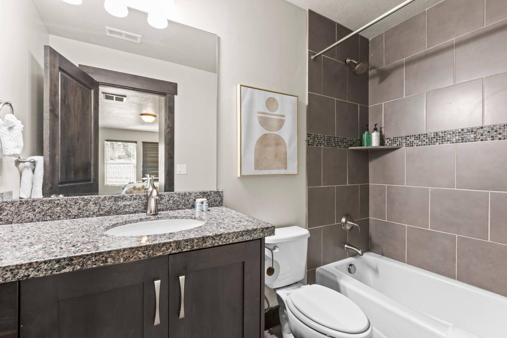 Your modern bathroom features elegant granite countertops, stylish tile work, and a relaxing tub-shower combo for your comfort.