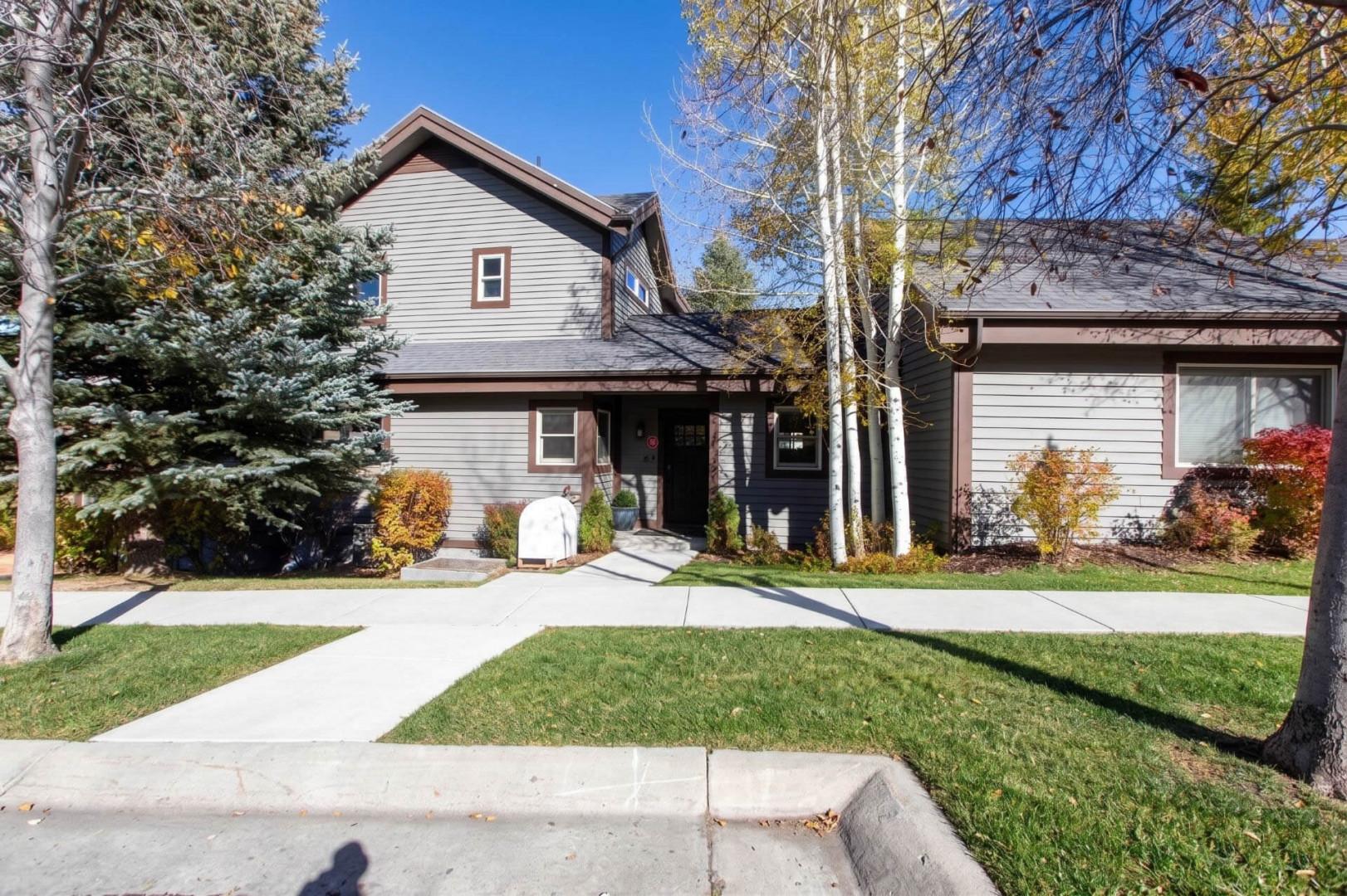 A well-maintained property nestled among mature trees and landscaped grounds, offering a welcoming mountain retreat in a quiet residential neighborhood.
