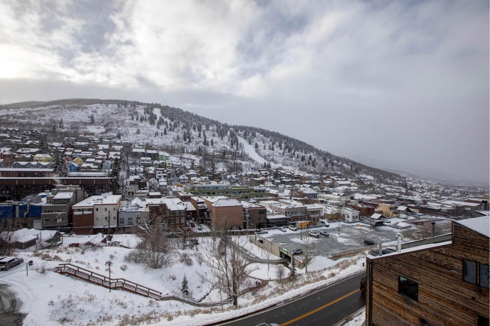 Snow-covered mountain town with ski slopes visible on the hillside, creating a picturesque winter destination.