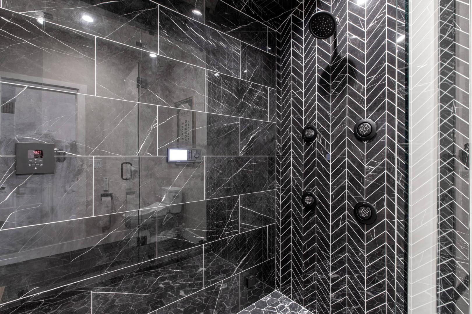 Step into your luxurious marble bathroom featuring a stunning rainfall shower with body jets and sophisticated herringbone tile accent wall.