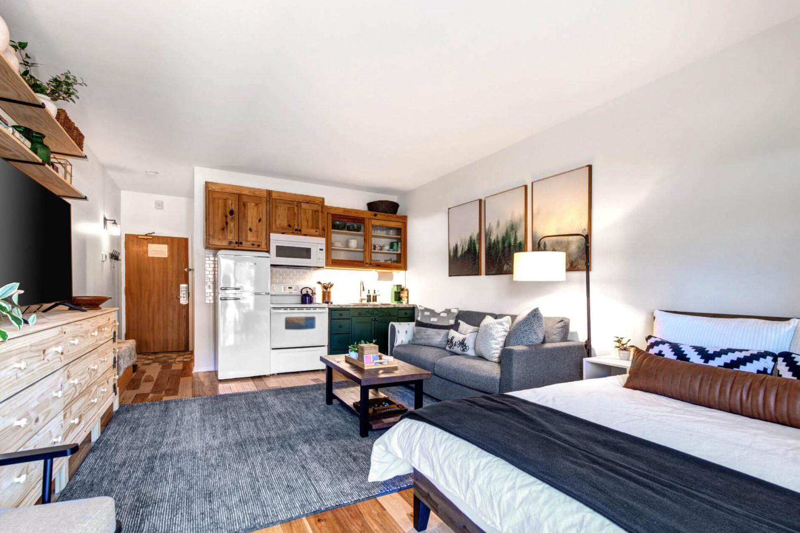 Cozy space with a sofa bed, center table, and kitchen area.