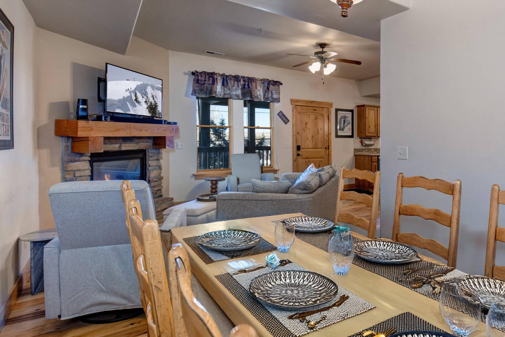 Gather around your mountain condo's warm stone fireplace and rustic dining table, where cozy evenings await after adventurous days.