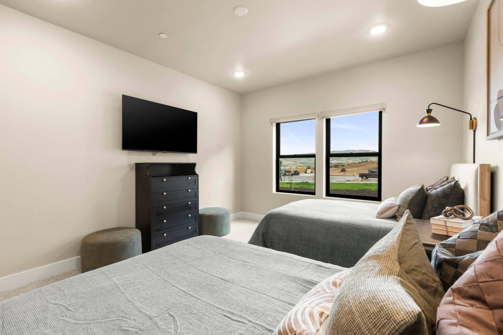 Sink into plush bedding and unwind in your serene retreat, where natural light pours in through generous windows and modern comforts await after a day of exploring.
