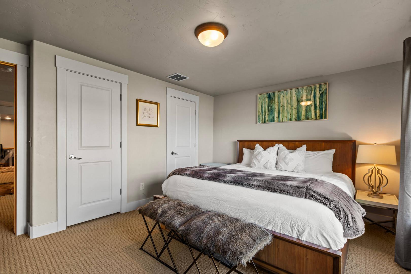Sink into this serene bedroom featuring plush bedding and warm lighting that creates your perfect retreat after exploring.