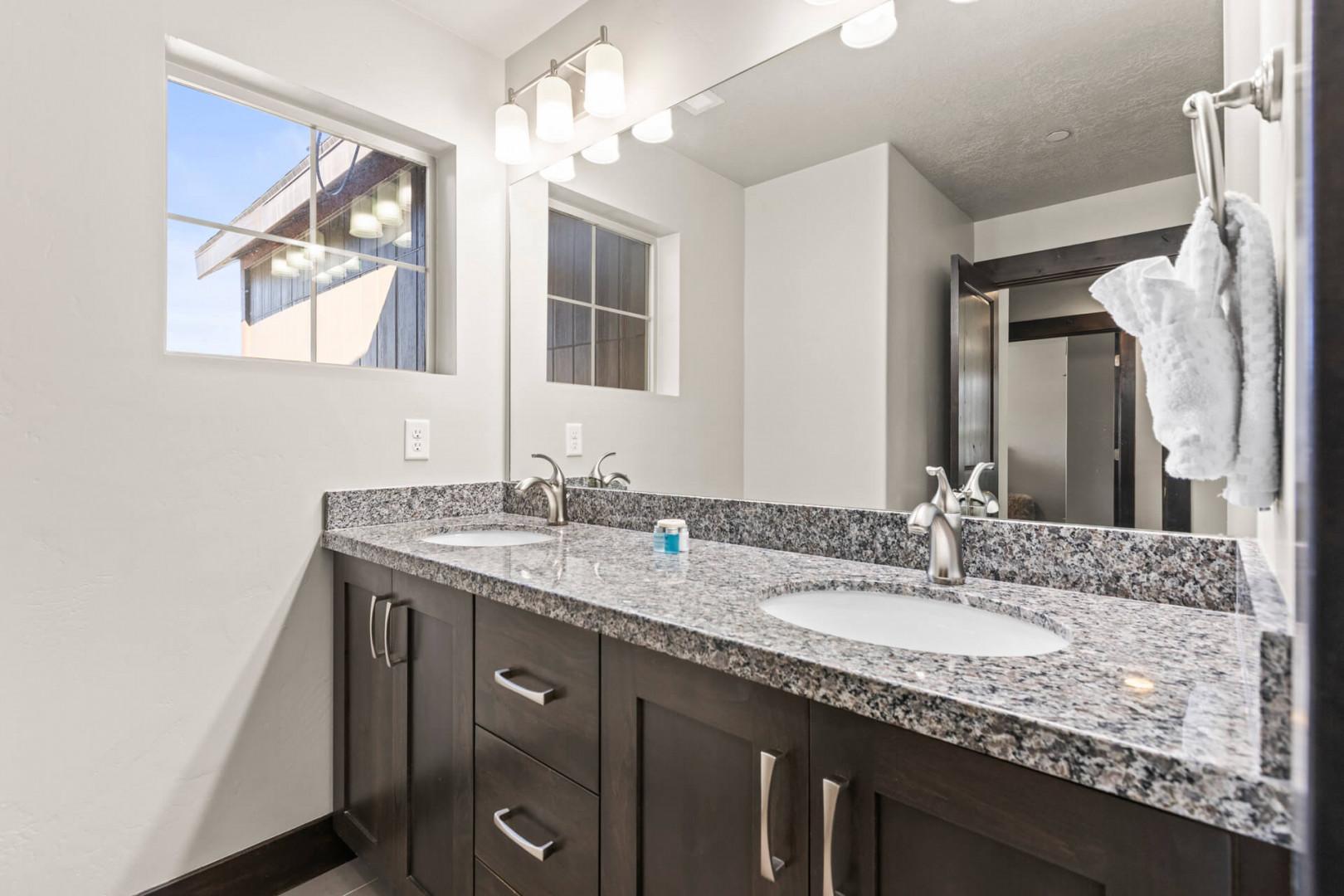 Enjoy dual vanities with granite counters and natural light streaming through your private window.
