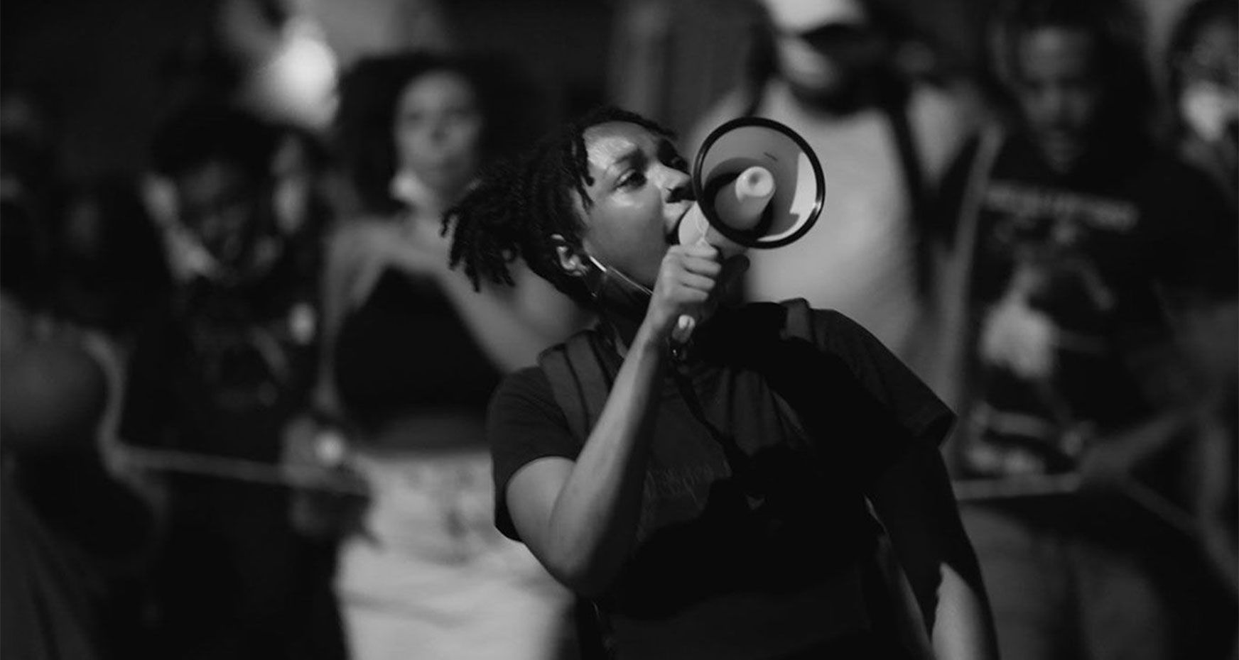 Woman at a rally speaking into a megaphone.