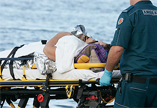 Image of injured boater on a gurney by the water