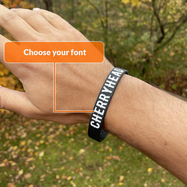 black wristband with debossed and ink filled white text highlighting your font choices
