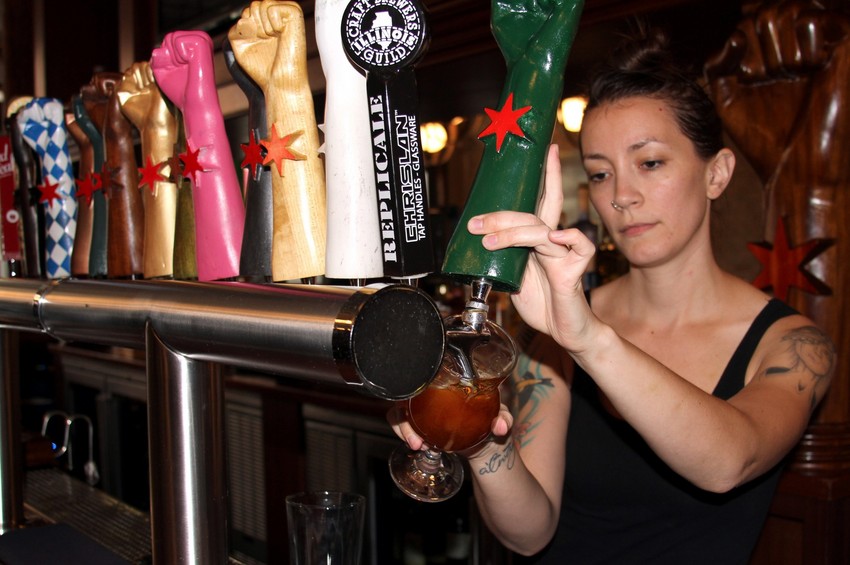 Bartender Alyssa Cornett pours a beer at Revolution Brewing in Logan Square. (Tricia Bobeda/WBEZ)