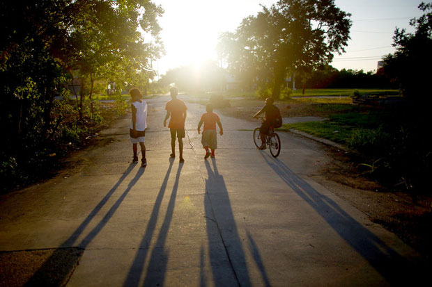 Children walk down one of the many empty streets next to the vacant lots where houses once stood. (David Gilkey/NPR)