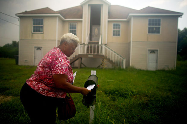 Bobbie Banks collects mail at her home, which she struggled to rebuild and still cannot occupy. Her first contractor took 05,000 of her money, but didn't finish the work. Then she had to rip out toxic drywall that another contractor used. (David Gilkey/NPR)