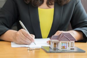 Businesswoman signing a contract for real estate investing