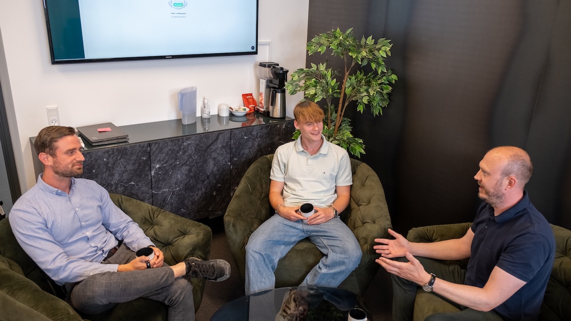 Fisker IT taler med en kunde over en kop kaffe