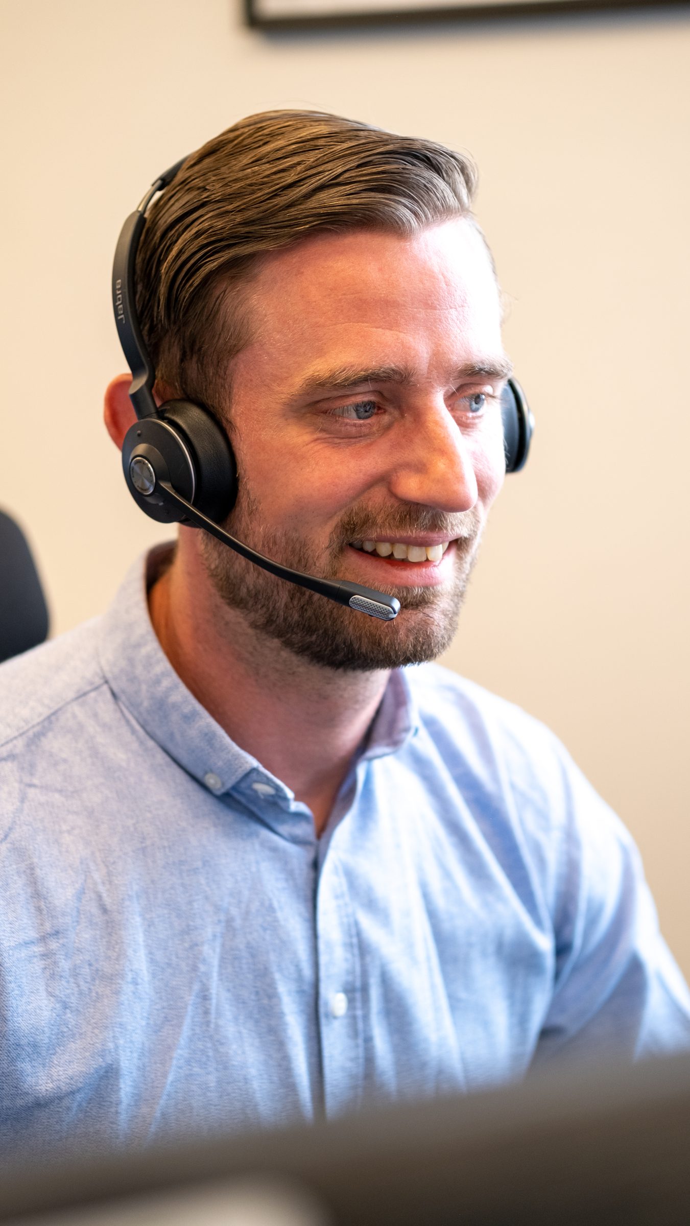 Supporter fra Fisker IT med headset hjælper en kunde