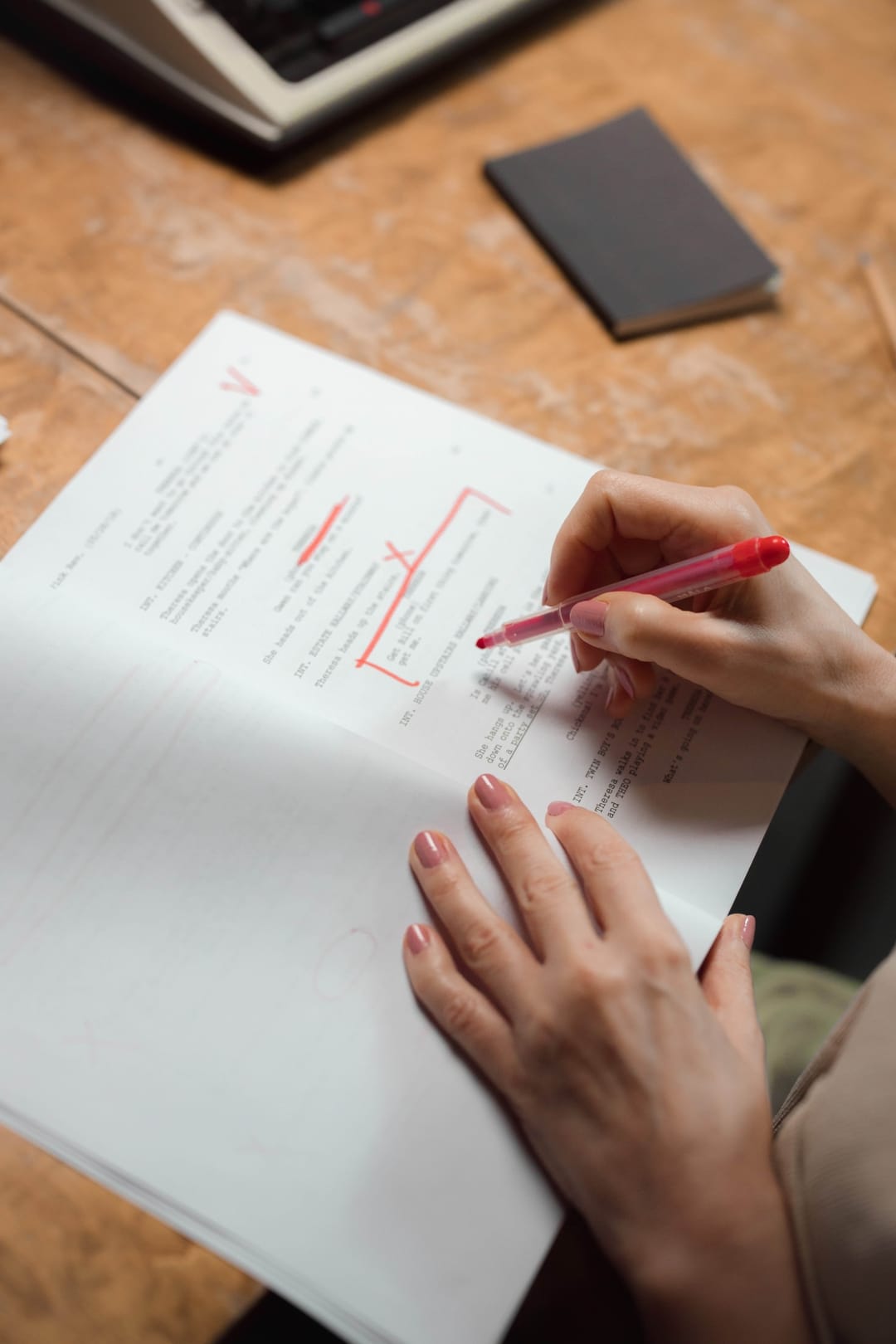 Une main annote un manuscrit au stylo