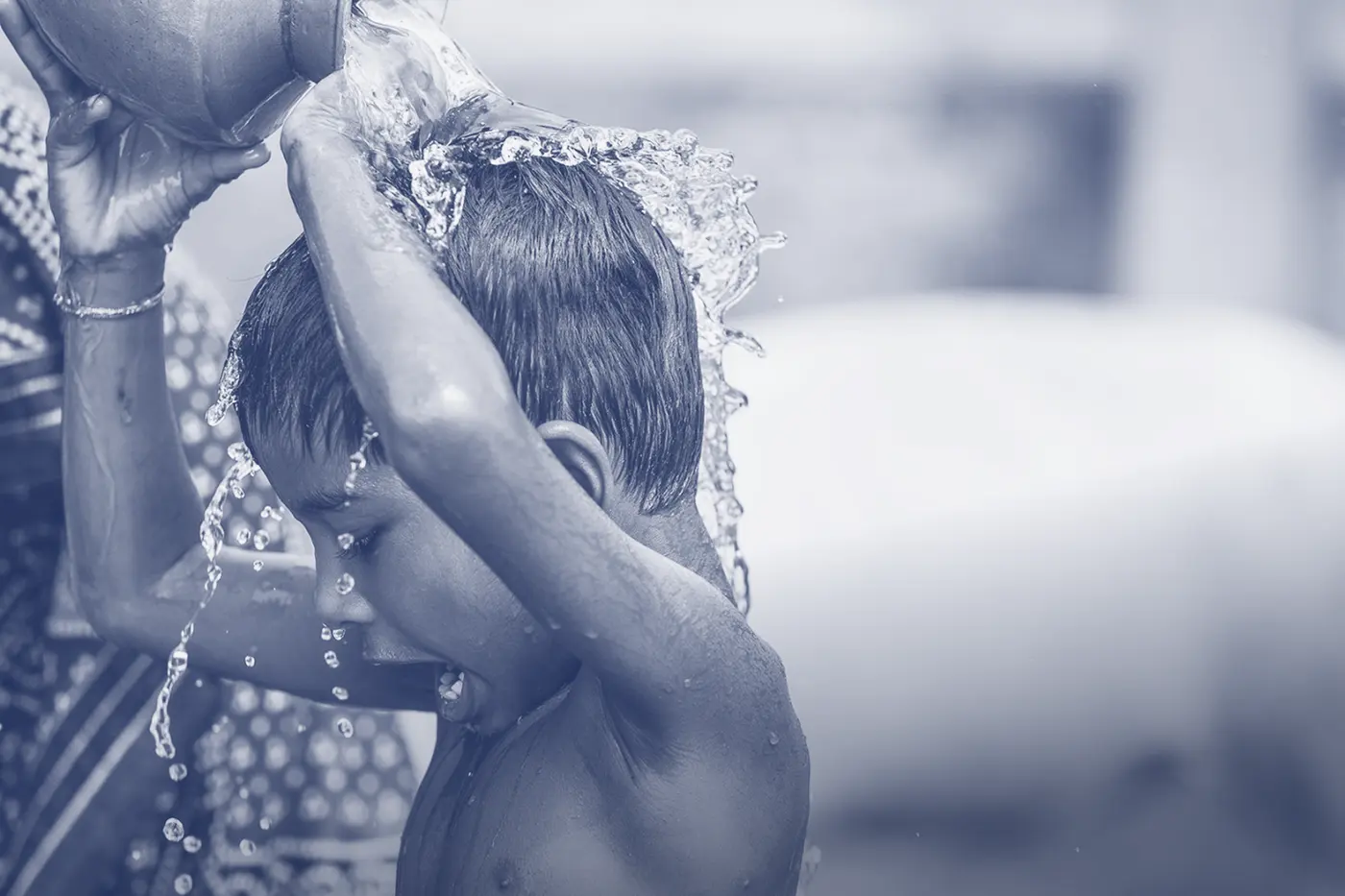 Child pouring clean water over their head
