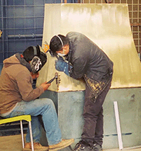 Dos artesanos trabajando una lámina de latón en el taller de Ciudad de México — Amoretti Brothers