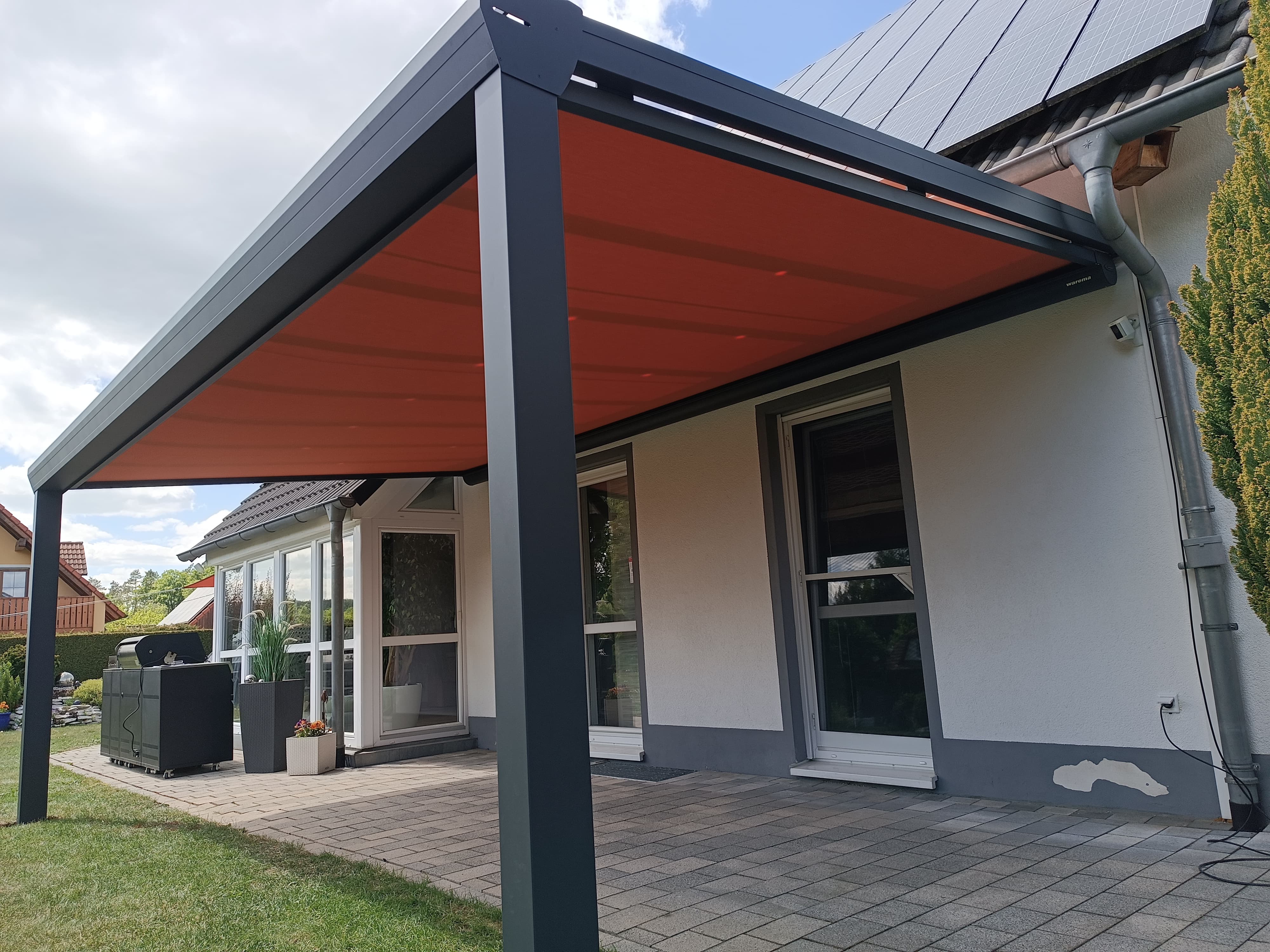 Terrassenüberdachung mit Aufdachmarkise an sonnigem Tag, die Schatten spendet