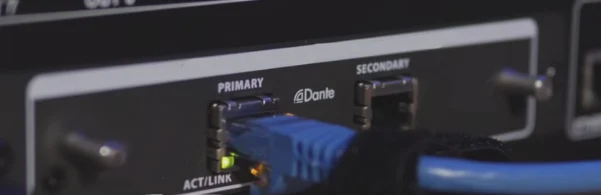 Netwerkkabel in de Dante-aansluiting van een audioapparaat